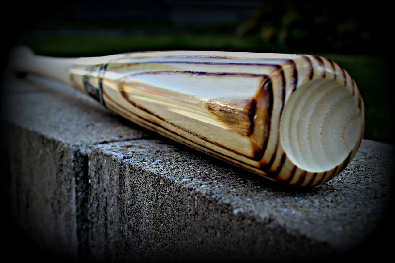 A wooden baseball bat resting on a stone ledge